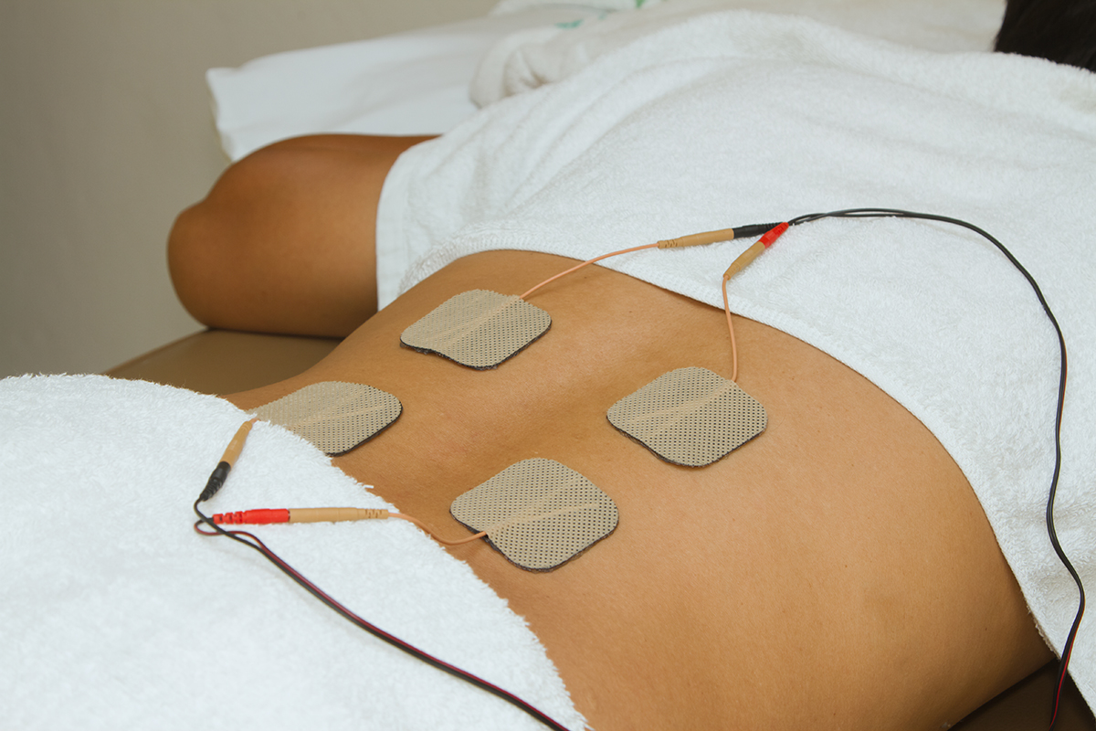 patient with electrical stimulation on her back