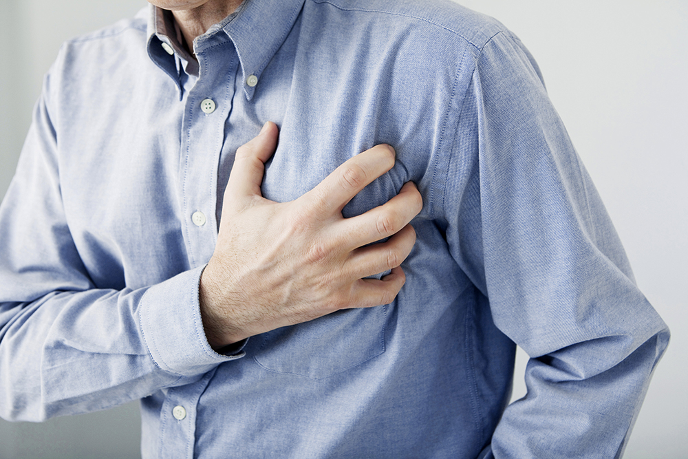 man holding his chest having a heart attack